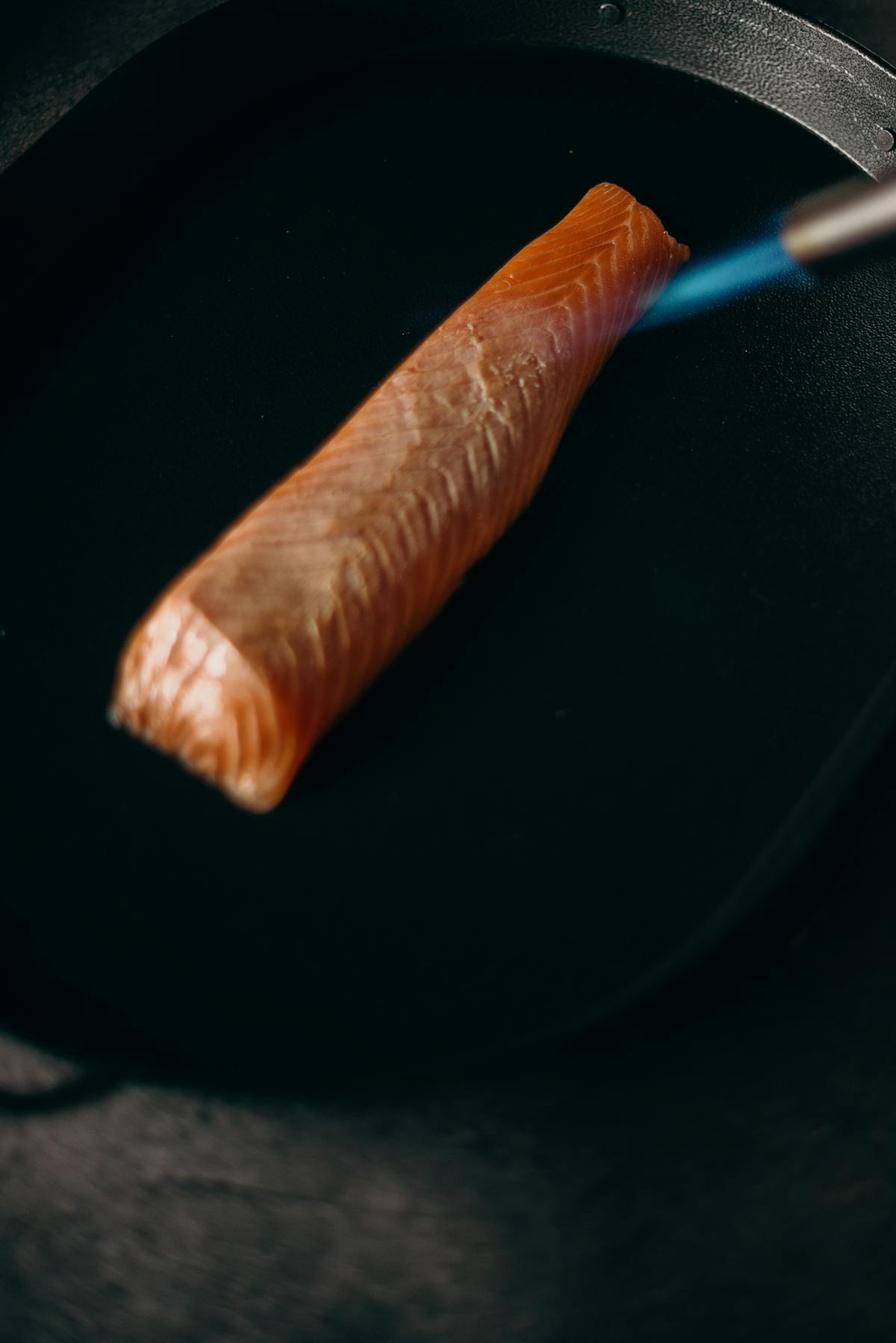 Fresh raw salmon fillet on a plate, the kind of vacuum-sealed fish that needs its packaging removed before fridge thawing